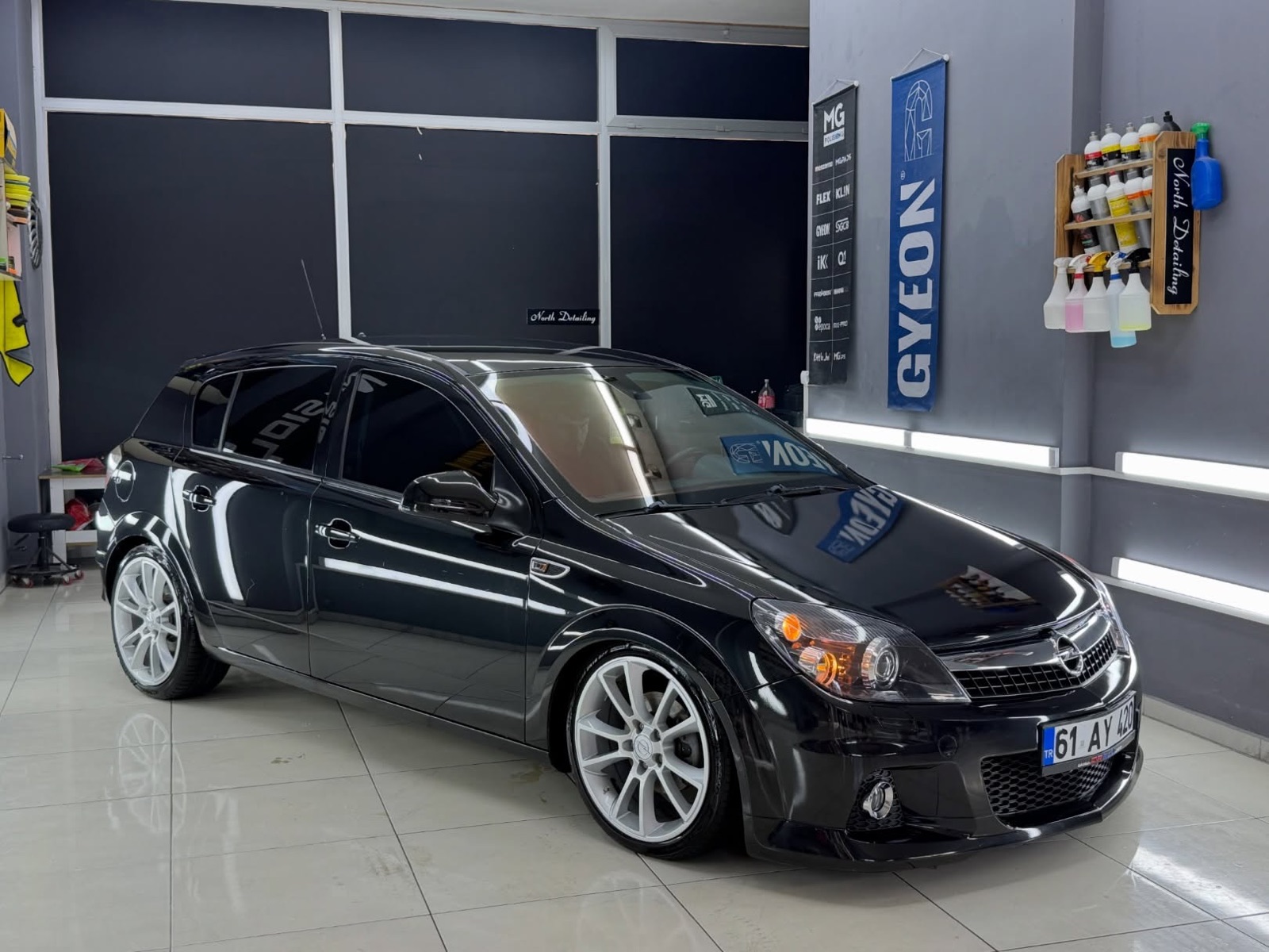 Seramik kaplama sonrası atölye ışıkları altında siyah Opel Astra